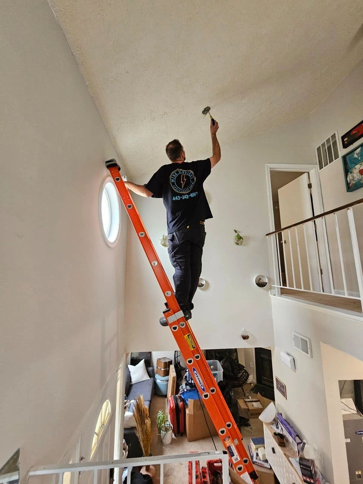 Mikk Services installing a vaulted-ceiling fixture in a Maryland home